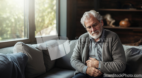 Image of Elderly Man in Pain Sitting on a Couch at Home