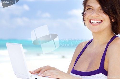 Image of woman with laptop computer on the beach