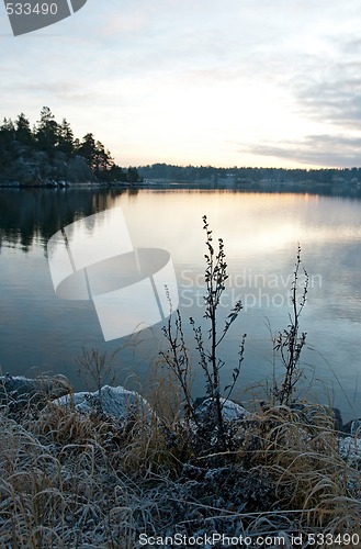 Image of View over calm lake in sunset