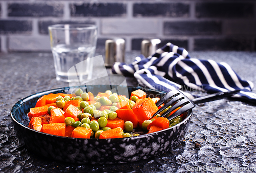 Image of fried pumpkin with green peas in bowl