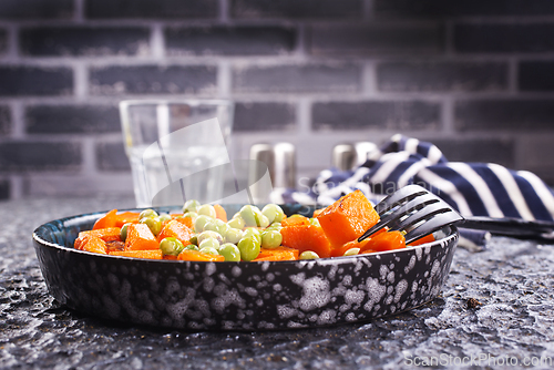 Image of fried pumpkin with green peas in bowl