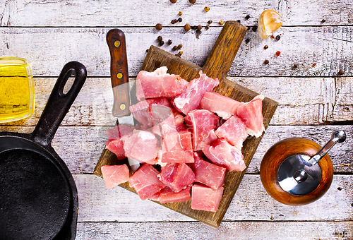 Image of raw meat with spice and salt on wooden board