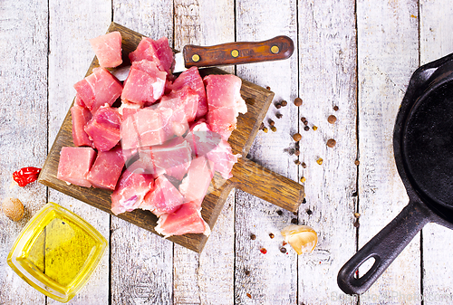 Image of raw meat with spice and salt on wooden board