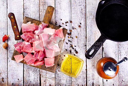 Image of raw meat with spice and salt on wooden board