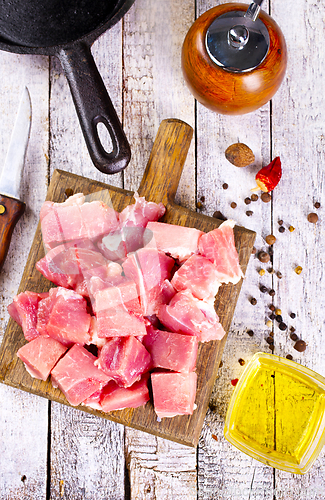 Image of raw meat with spice and salt on wooden board