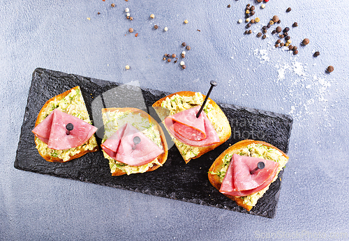 Image of Rye bread sandwich with sliced Italian ham and a creamy homemade avocado cashew spread.