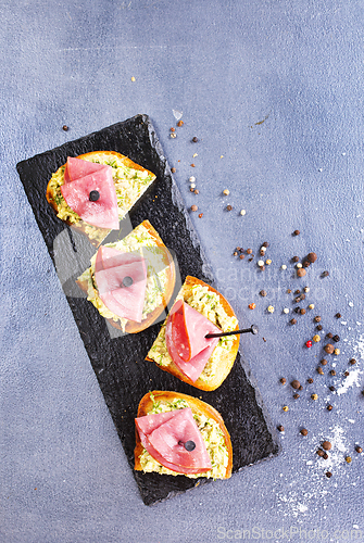 Image of Rye bread sandwich with sliced Italian ham and a creamy homemade avocado cashew spread.