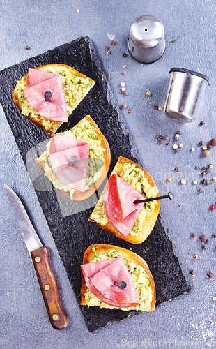 Image of Rye bread sandwich with sliced Italian ham and a creamy homemade avocado cashew spread.