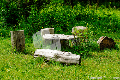 Image of Rustic wooden seating area with natural decor in lush green fore