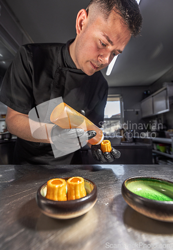 Image of Pastry chef garnishing small cakes