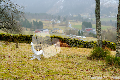 Image of Scenic rural landscape with a white chair overlooking a foggy va