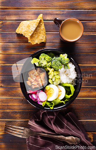 Image of Rice with red fish, green beans and broccoli in a black plate. Diet.