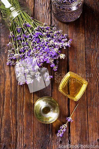 Image of lavender essential oil in glass bottle with fresh lavender flowers,