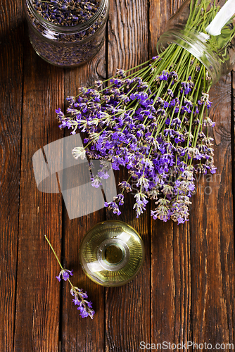 Image of lavender essential oil in glass bottle with fresh lavender flowers,