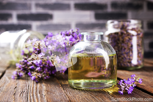 Image of lavender essential oil in glass bottle with fresh lavender flowers,