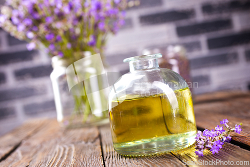 Image of lavender essential oil in glass bottle with fresh lavender flowers,