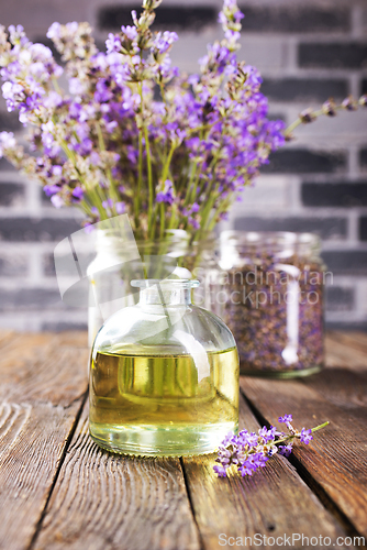 Image of lavender essential oil in glass bottle with fresh lavender flowers,