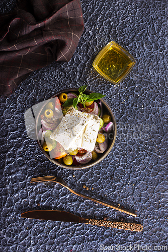 Image of Greek salad of fresh juicy vegetables, feta cheese, herbs and olives
