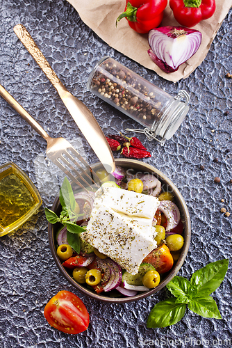 Image of Greek salad of fresh juicy vegetables, feta cheese, herbs and olives