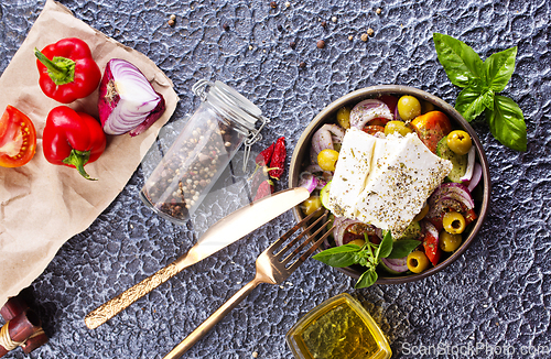 Image of Greek salad of fresh juicy vegetables, feta cheese, herbs and olives