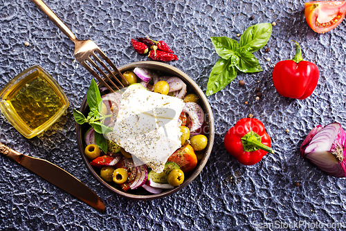 Image of Greek salad of fresh juicy vegetables, feta cheese, herbs and olives