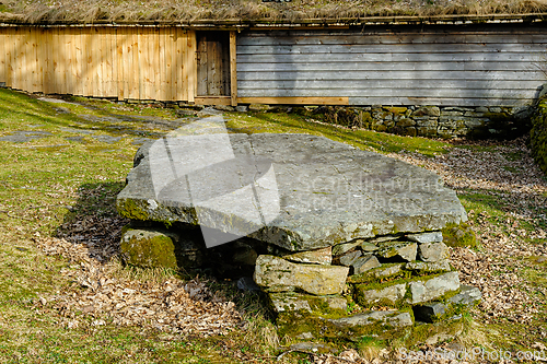 Image of Moss-covered stone table resting on ancient stone structure in r