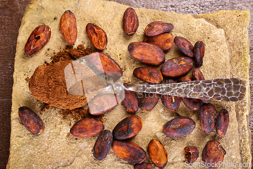 Image of Cocoa powder and cacao beans on stone background