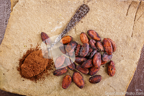 Image of Cocoa powder and cacao beans on stone background
