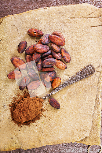 Image of Cocoa powder and cacao beans on stone background