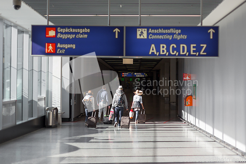 Image of Unrecognizable People With Bags And Suitcase Walking In Airport Terminal. Rear View Of Passengers On Their Way To Flight Boarding Gate, Ready For Business Travel Or Vacation Journey.