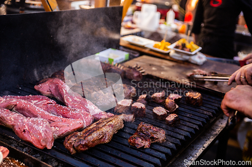Image of Some excellent pieces of Argentinian beef on a charcoal grill being prepared at open kitchen street food festival in Ljubljana, Slovenia.