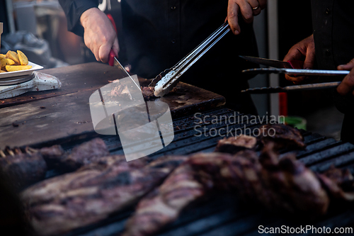 Image of Some excellent pieces of Argentinian beef on a charcoal grill being prepared at open kitchen street food festival in Ljubljana, Slovenia.