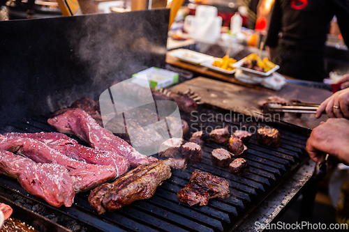 Image of Some excellent pieces of Argentinian beef on a charcoal grill being prepared at open kitchen street food festival in Ljubljana, Slovenia.