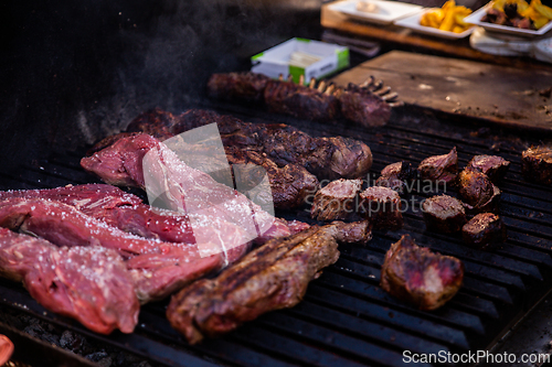 Image of Some excellent pieces of Argentinian beef on a charcoal grill being prepared at open kitchen street food festival in Ljubljana, Slovenia.