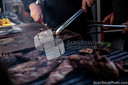 Image of Some excellent pieces of Argentinian beef on a charcoal grill being prepared at open kitchen street food festival in Ljubljana, Slovenia.