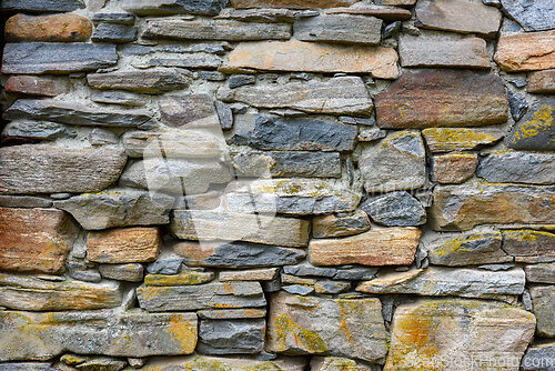 Image of Natural stone wall showcasing a mix of gray and beige stones in 