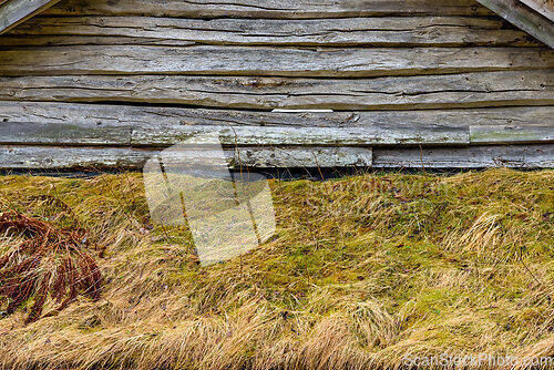 Image of Rustic wooden structure with weathered texture and grassy foregr