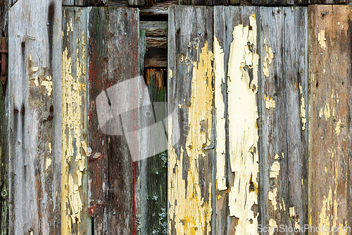 Image of Weathered wooden boards reveal layers of paint and history on an