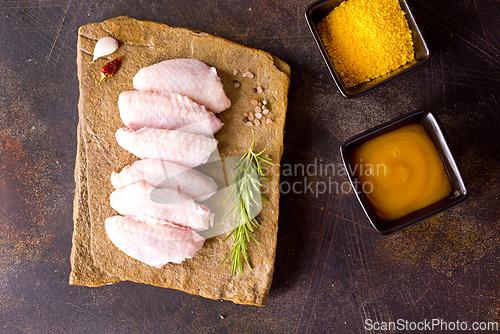 Image of Raw chicken wings with ingredients for cooking