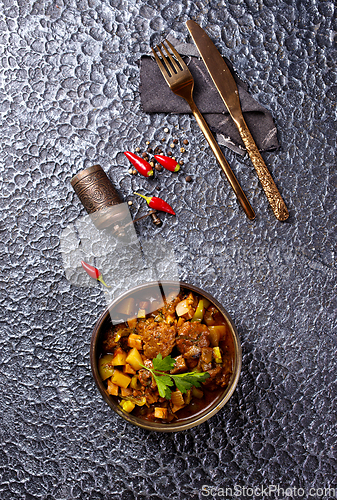 Image of Summer Vegetable spicy stew of zucchini, potatoes, peppers, onions, tomatoes and eggplant in a bowl on the table.