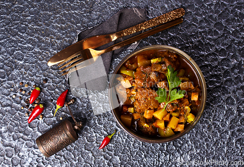 Image of Summer Vegetable spicy stew of zucchini, potatoes, peppers, onions, tomatoes and eggplant in a bowl on the table.