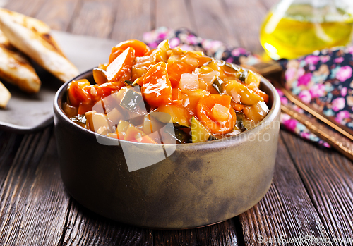 Image of Summer Vegetable spicy stew of zucchini, potatoes, peppers, onions, tomatoes and eggplant in a bowl on the table.