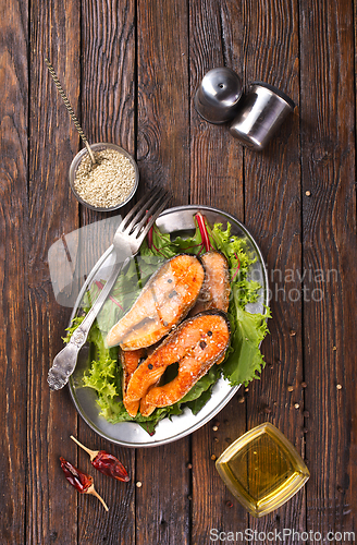 Image of roast salmon steaks with fresh salad on plate
