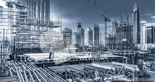 Image of Laborers working on modern constraction site works in Dubai. Fast urban development consept