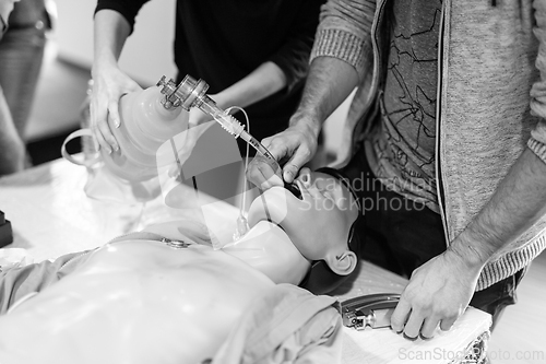 Image of Medical doctor specialist expert displaying method of patient intubation on hands on medical education training and workshop. Black and white image.