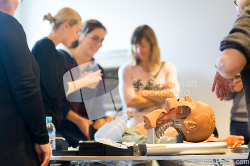 Image of Medical doctor specialist expert displaying method of patient intubation on hands on medical education training and workshop. Participants learning new medical procedures and techniques.