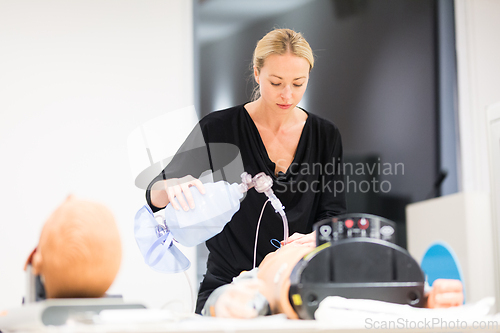 Image of Medical doctor specialist expert displaying method of patient intubation technique on hands on medical education training and workshop