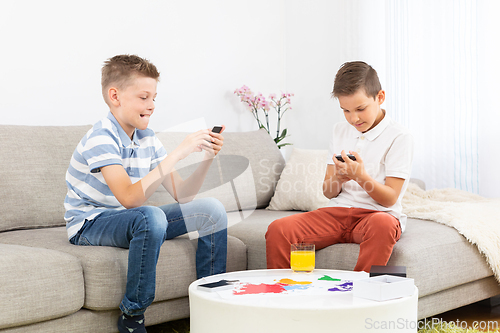 Image of Two kids playing card game spending quality leisure time at home.
