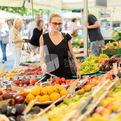 Image of Woman buying fruits and vegetables at local food market. Market stall with variety of organic vegetable