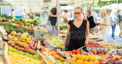 Image of Woman buying fruits and vegetables at local food market. Market stall with variety of organic vegetable